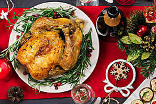 烤火鸡。圣诞晚餐。圣诞桌上摆着一只火鸡，上面装饰着明亮的金属丝和蜡烛。炸鸡，餐桌。d族