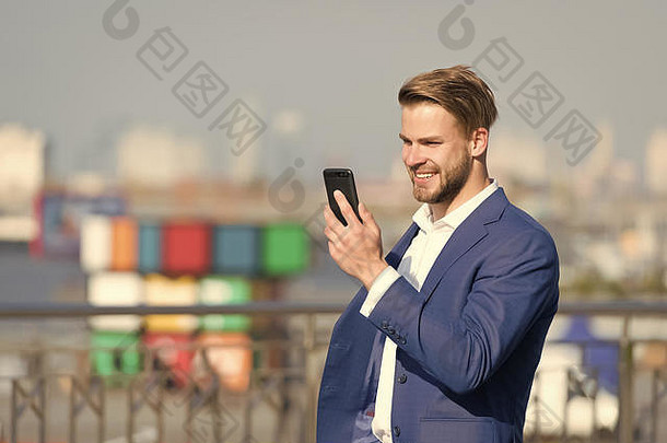 男人。微笑正式的西装移动电话户外快乐商人智能手机阳光明媚的阳台业务沟通技术业务生活方式概念