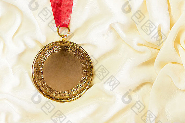一块粗糙的金牌庄严地镶嵌在米色丝绸上。