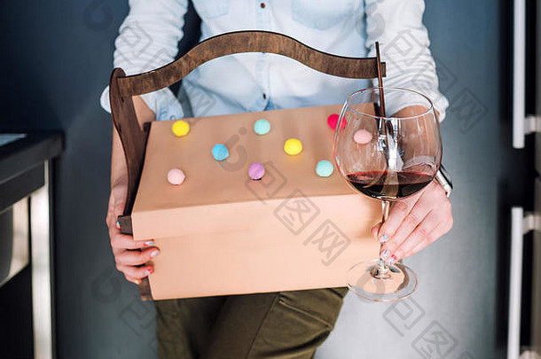认不出来女人持有礼物木篮子玻璃红色的酒黑暗背景礼物盒子现在庆祝活动概念
