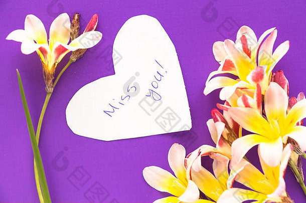 在心形的音符里写着思念你的话！紫色表面上有花。