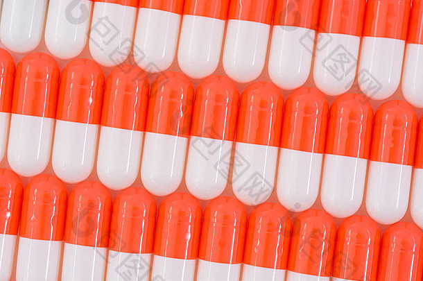 药丸特写-胶囊形式制成的明胶。橙色/白色药片。比喻在高药价问题上与美国制药公司较量。