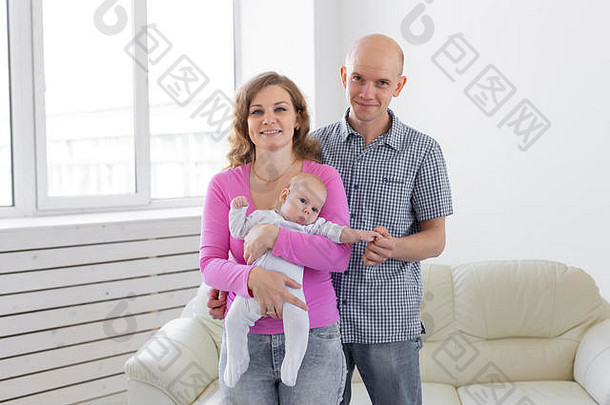 家庭、童年和为人父母的概念-父亲、母亲在室内抱着可爱的婴儿
