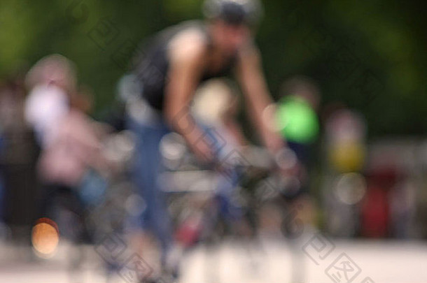 焦点图像骑自行车的人骑自行车前景骑自行车的人树建筑背景