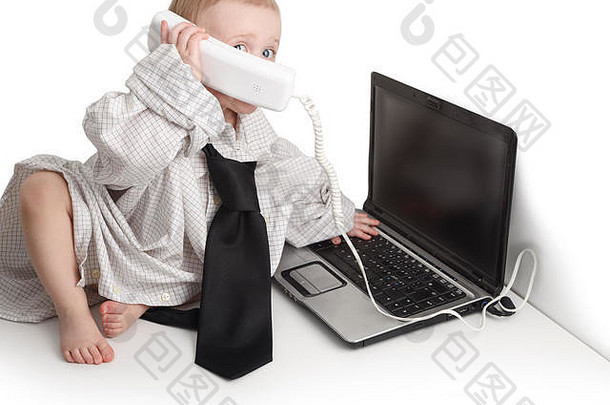 一到二岁的白人男孩，穿着白<strong>底商</strong>务衬衫和领带，坐在电话和笔记本电脑上