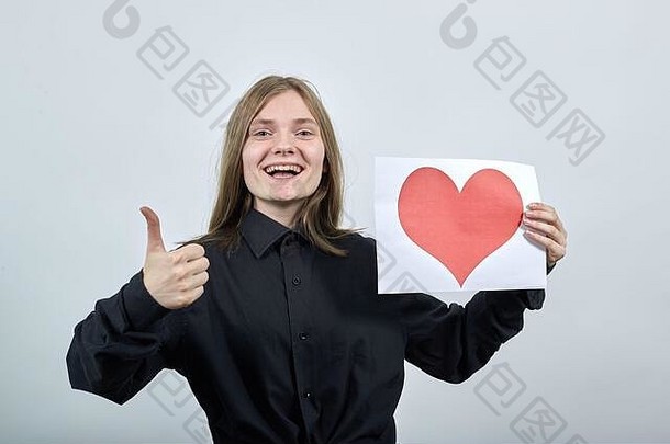 迷人的白人年轻女子，手里拿着一张红心的照片，很喜欢。