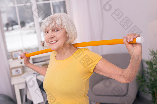快乐的上了年纪的女人摆姿势锻炼健康魔杖