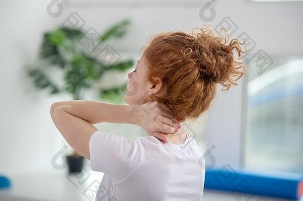 红发女病人按摩痛苦的脖子