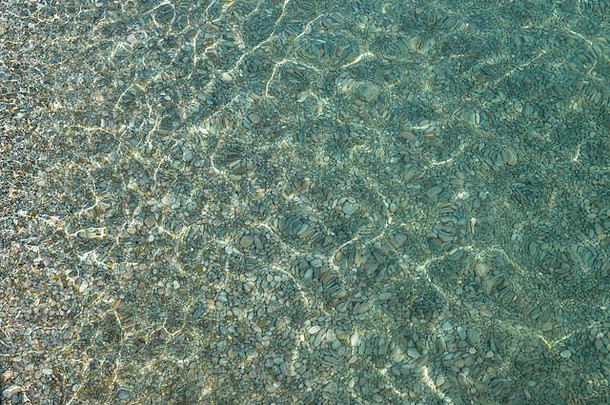 闪烁的阳<strong>光</strong>照射在卵石海床上，在浅滩清澈的海水下作为自然<strong>背景</strong>。