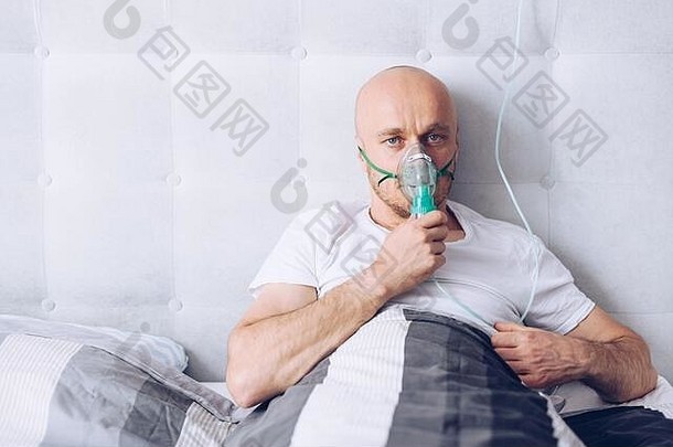在床上通过氧气面罩呼吸的人。2019冠状病毒疾病。
