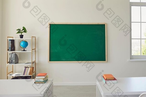 白色学校教室内部。明亮的房间，有窗户，桌子，椅子，绿色木板