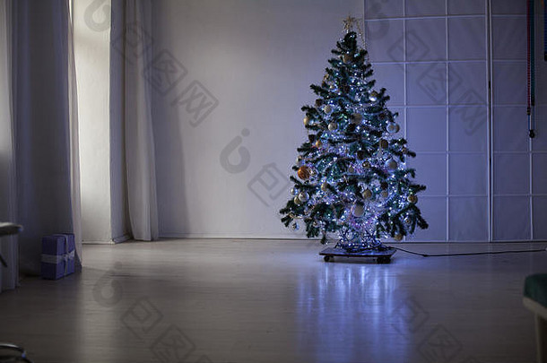 白色房间内的圣诞树赠送新年节日花环灯
