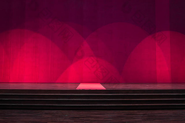 舞台上有地毯，中间有地毯，剧院里有红色的窗帘。