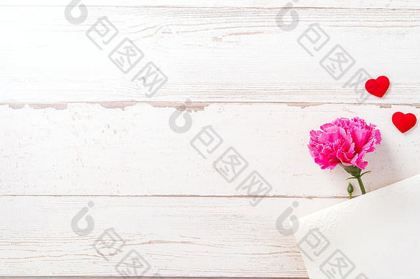 五月母亲节概念摄影-美丽的康乃馨和心形与白色空卡片隔离在明亮的木桌上，空间，平面
