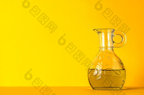 黄色背景玻璃罐中的橄榄油，带有复印空间