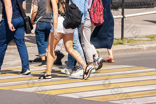 夏日，在城市人行横道上<strong>横穿马路</strong>的行人。腿部特写