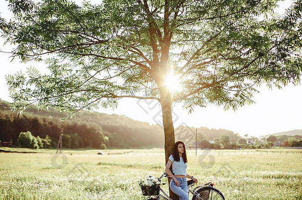 在温暖<strong>的</strong>阳光下，女孩骑着自行车和小<strong>狗</strong>在田野里散步