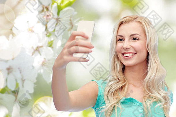 微笑年轻的女人采取自拍智能<strong>手机</strong>