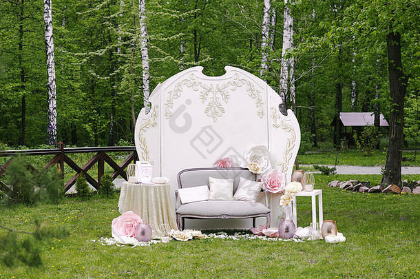 带新婚夫妇姓名的摄影区和带花卉装饰的沙发
