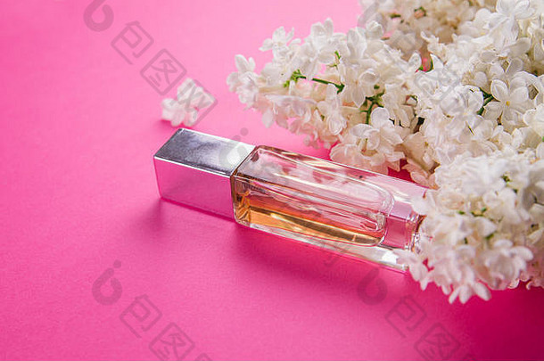 一瓶香水，粉红色背景上有白色丁香