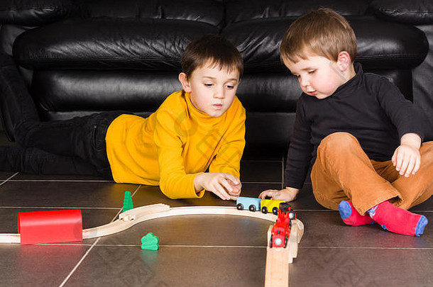 孩子们玩木玩具火车兄弟构建木铁路首页