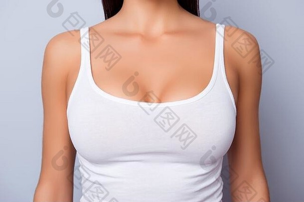 浅蓝色背景上的纯白单品青铜色皮肤的完美女士胸部特写