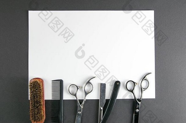 剪刀、理发器、梳子、危险剃须刀放在黑色背景的白色床单上。美容理念