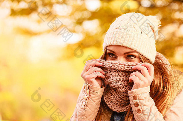 年轻的女人走秋天的公园隐藏脸温暖的羊毛围巾美丽的阳光明媚的秋天的一天