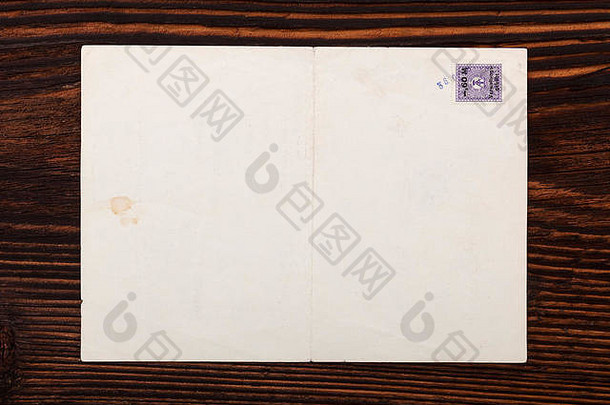 棕色木桌上印有邮票的旧信封，俯视图。