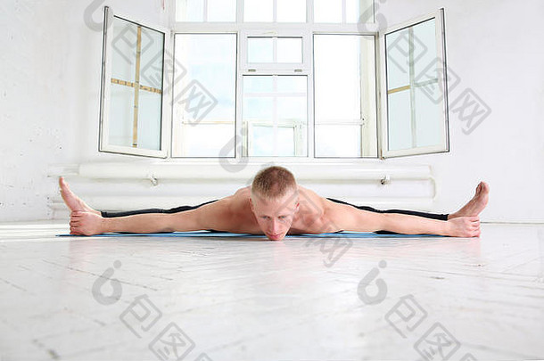 运动型男子练习<strong>瑜伽</strong>。乌帕维斯塔科纳萨纳。广角坐姿前弯。