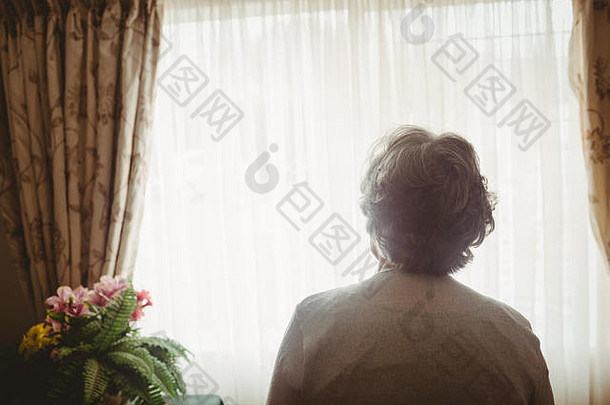 一位老妇人望着窗外