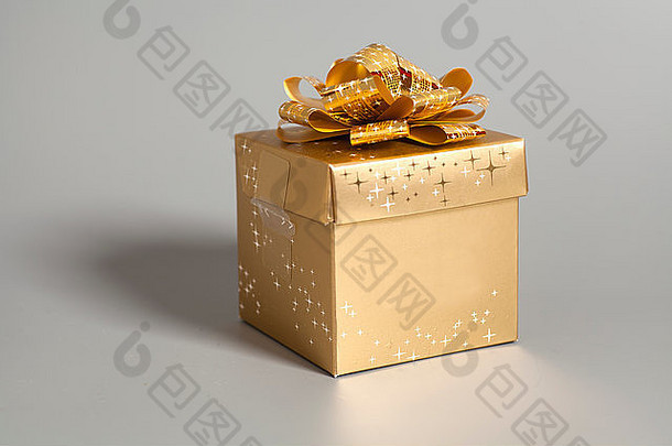 灰色背景上带金色丝带的金色礼品盒