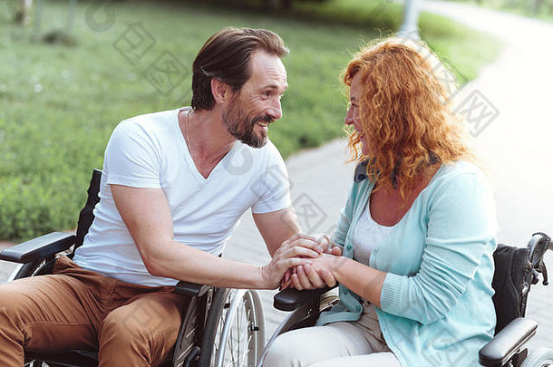 支持成熟的夫妇轮椅聊天微笑
