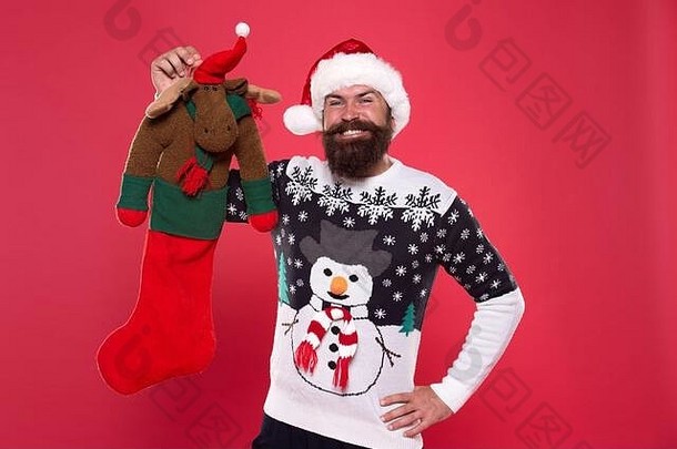 有趣的玩具礼物。留胡子的男人拿着圣诞礼物。快乐的时髦人士从圣诞老人那里得到了礼物。圣诞节和新年。寒假。节日的问候。假日大减价。圣诞节前礼品。