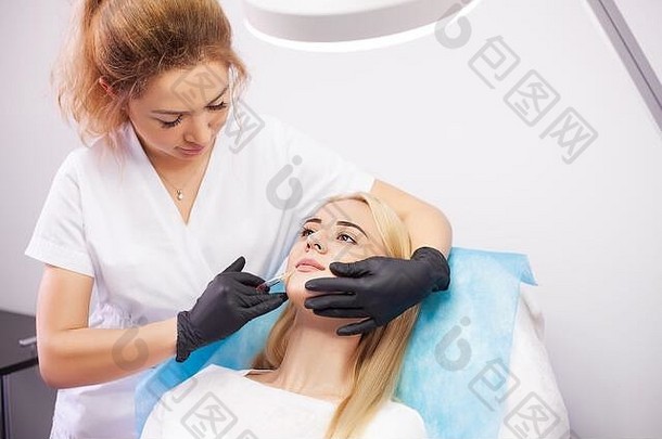 一名妇女在美容诊所接受唇部注射