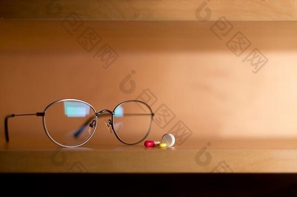 眼镜和一小部分药片放在架子上