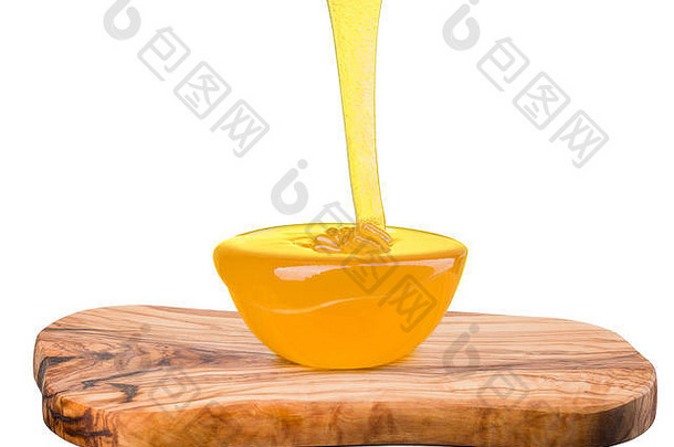 装满蜂蜜的玻璃碗和落在白色木板上的蜂蜜喷射