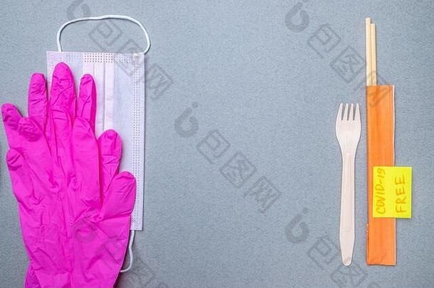叉子、2019冠状病毒疾病、一个医用面具和粉红色乳胶手套和一个带有铭文的CVID-19自由平面的贴纸。提供安全、联合国服务的概念