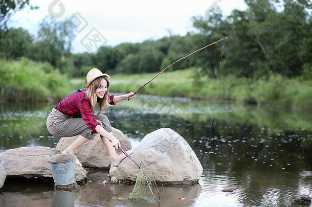 一个拿着鱼竿的河边女孩