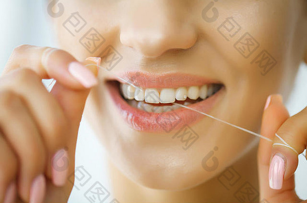 牙科护理。微笑着用牙线刷牙的女人。高分辨率图像