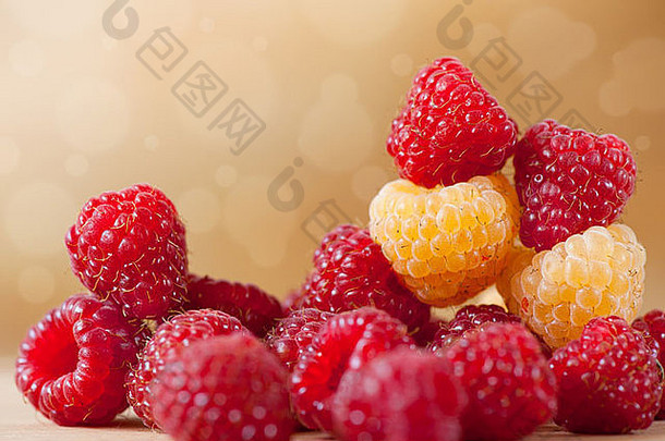 鲜红色和金色的树莓果实堆在一起