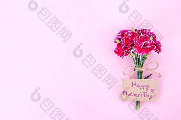 五月母亲节创意概念摄影-美丽盛开的康乃馨用蝴蝶结系在一起，卡夫文本卡孤立在明亮的现代桌子上，空间，