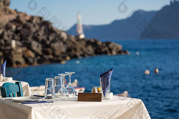 爱琴海前的<strong>预定</strong>桌，在模糊的背景<strong>中</strong>，你可以看到圣托里尼的海岸线。