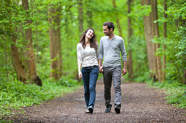 一对年轻夫妇在森林里散步的情景