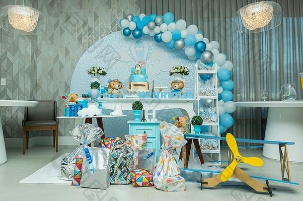 男孩的生日派对，带蓝色粉彩装饰。装饰以飞行员为主题，泰迪熊、云、糖果。精美的糖果桌