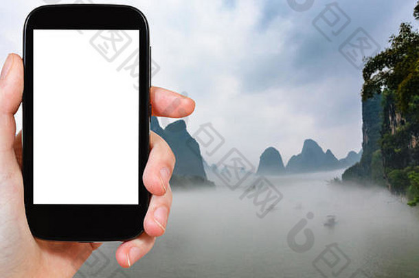 旅游理念——春天的早晨，中国阳朔县兴平镇附近河流上的雾气在智能手机上拍摄