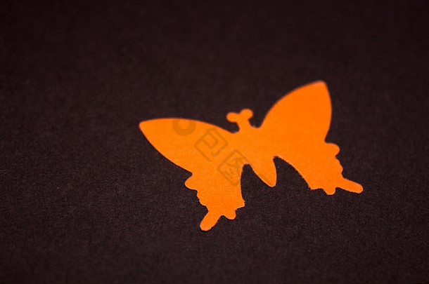 深色背景上的橙色纸蝴蝶