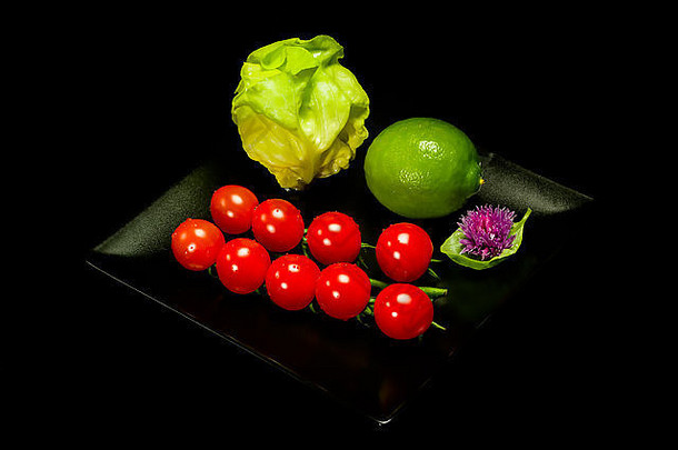 生菜、莱姆、罗勒和番茄，黑色背景