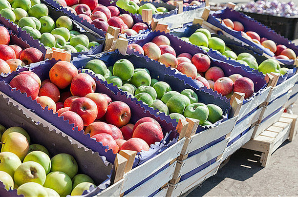 在农贸市场出售的新鲜红苹果和绿苹果
