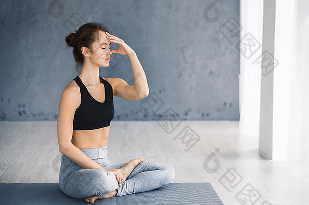 年轻女子练习瑜伽，交替鼻孔呼吸法